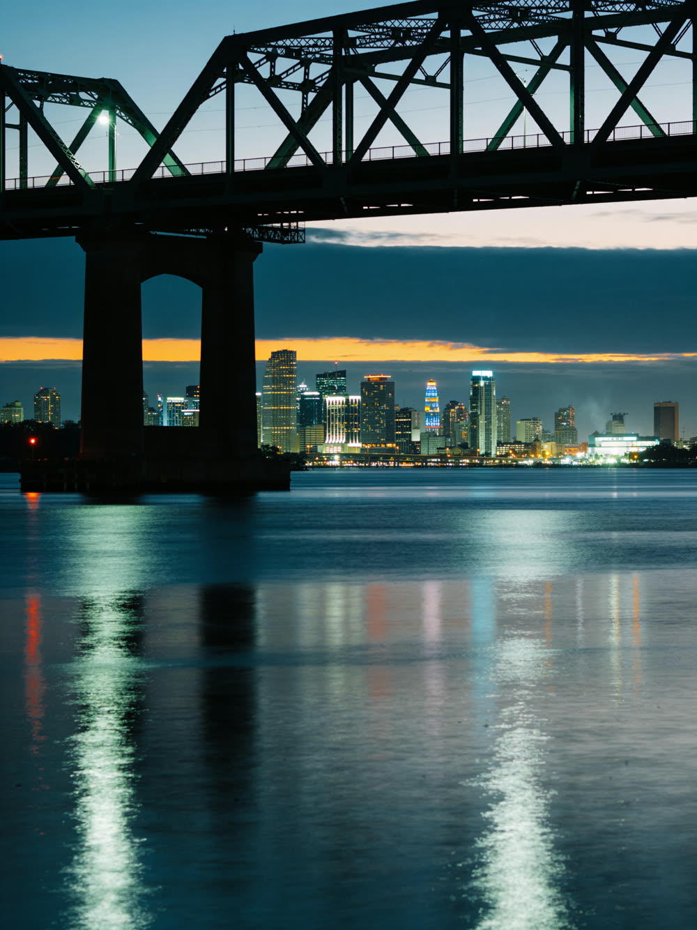 Downtown Jacksonville at dusk, lights coming on across the St. Johns River